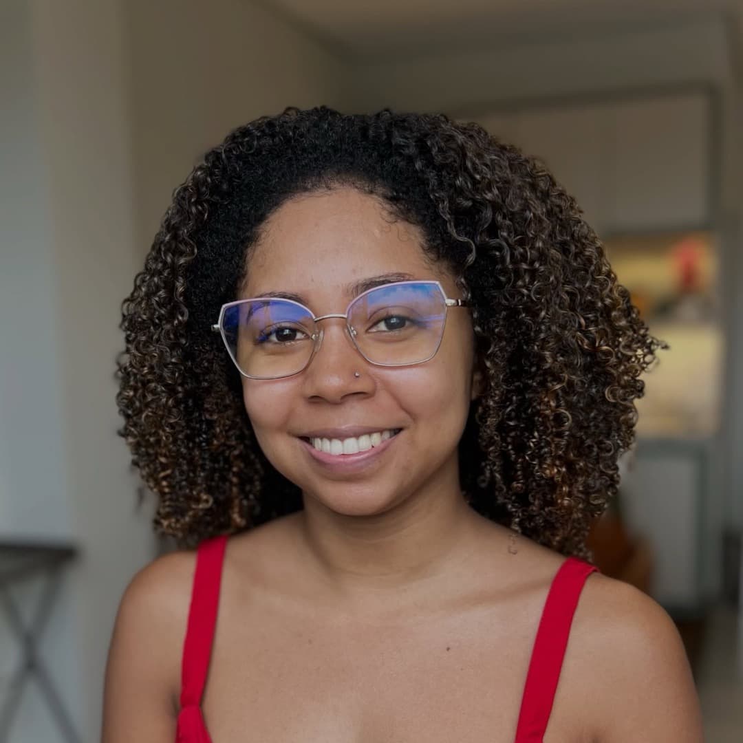 Cliente de óculos do Studio Raízes com cachos curtos